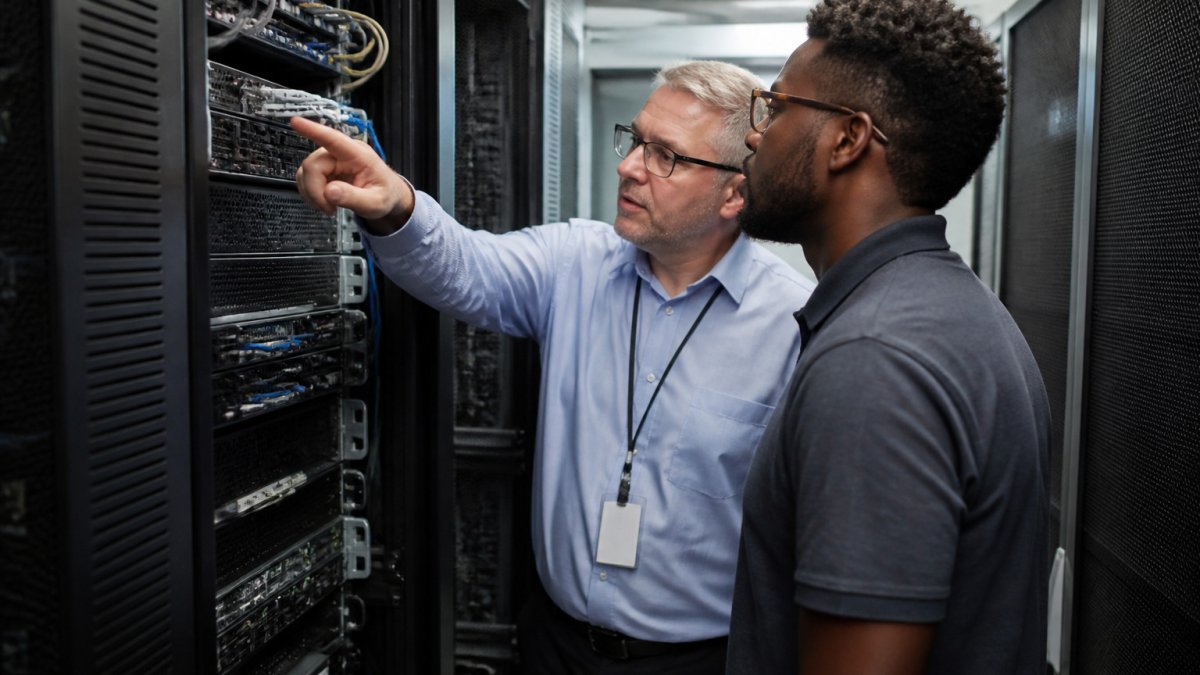 In-house administrator and technician collaborating on a server rack for co-managed IT support
